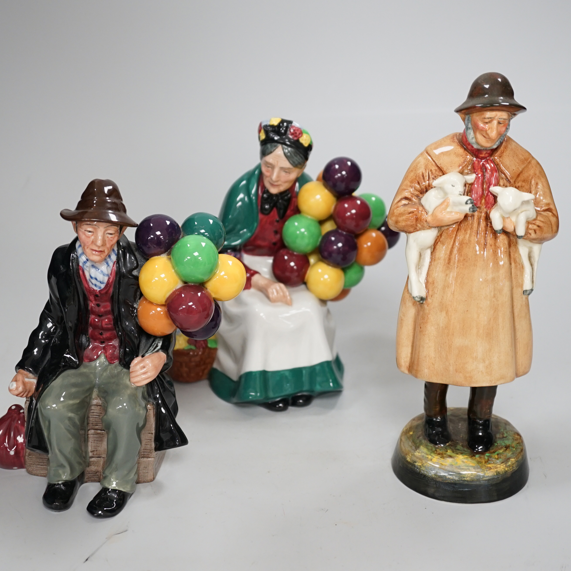 Three Royal Doulton figures comprising Lambing Time HN1890 and The Balloon man HN1954, the largest 23cm high